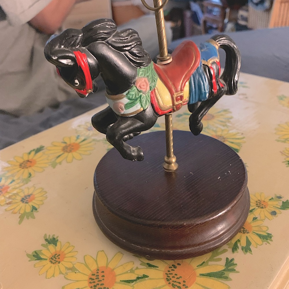 Mid-center carousel music box. Spins and sings. Works well